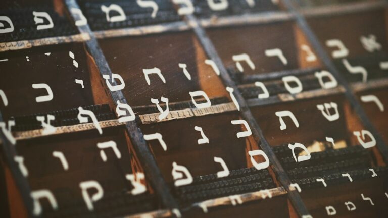 A family sitting at a kitchen table labeling everyday objects with both English and Hebrew words.