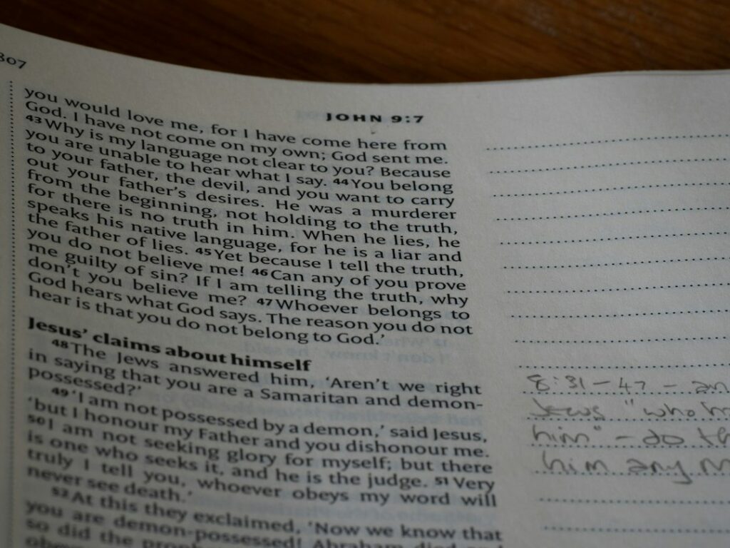 Beginner students study Hebrew letters and grammar in notebooks around a table.