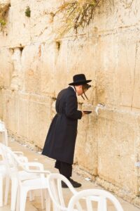 Two people study a Hebrew street map while one points toward a nearby intersection.
