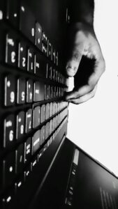 Adult typing a Hebrew message on a smartphone beside a notebook showing Hebrew letters.