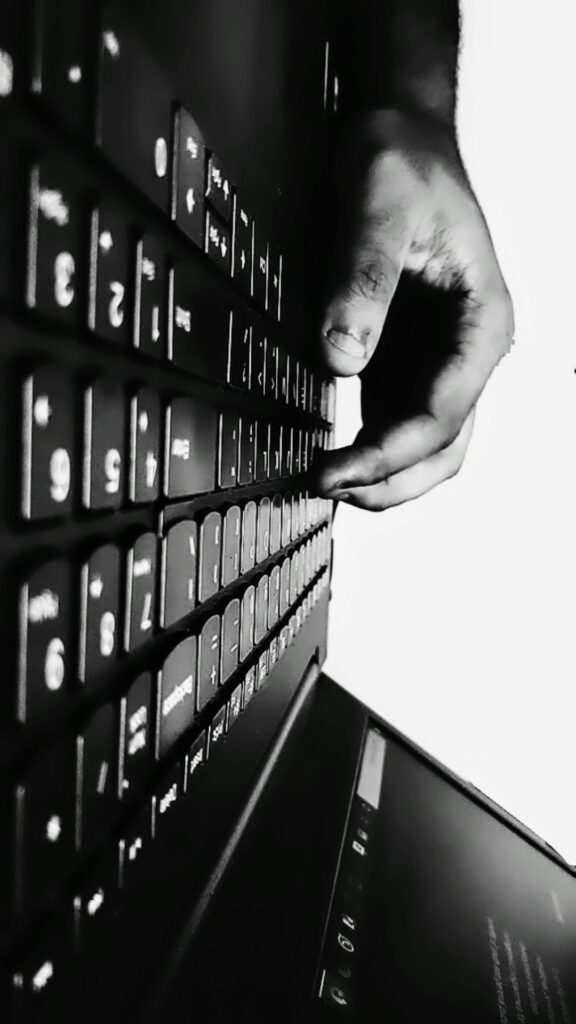 Adult typing a Hebrew message on a smartphone beside a notebook showing Hebrew letters.