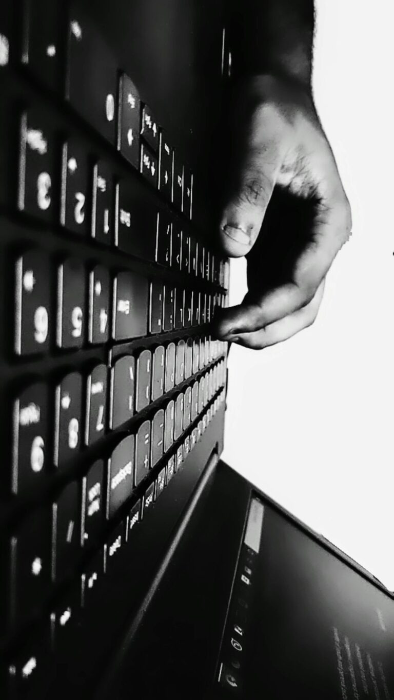 Adult typing a Hebrew message on a smartphone beside a notebook showing Hebrew letters.