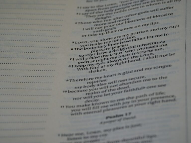 Person reading a Hebrew menu with Hebrew text, food descriptions, and handwritten notes at a table.