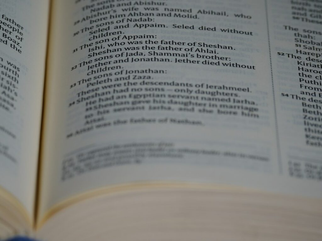 A student studies an open Hebrew-English dictionary beside handwritten vocabulary notes and a Hebrew reading book.