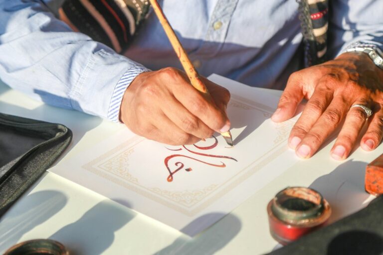 Student writing Hebrew letters and short sentences in a lined notebook at a home study desk.