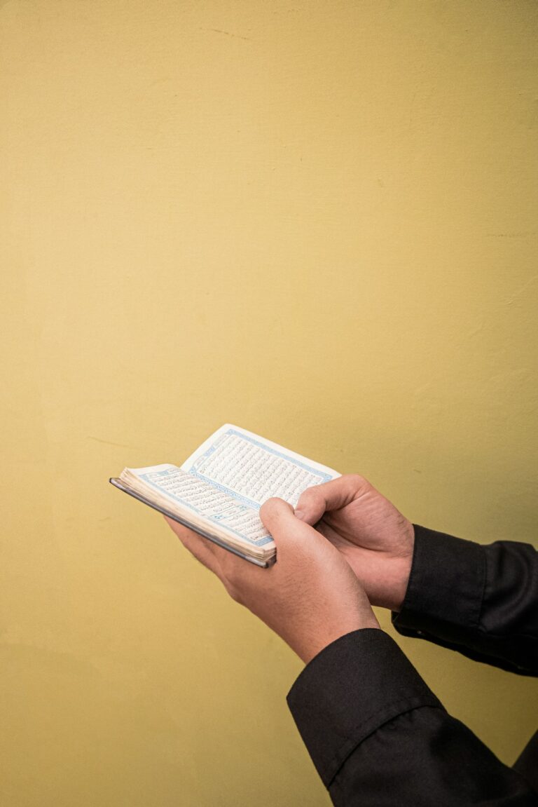 Learner practicing Hebrew letters on a smartphone beside a notebook and headphones.