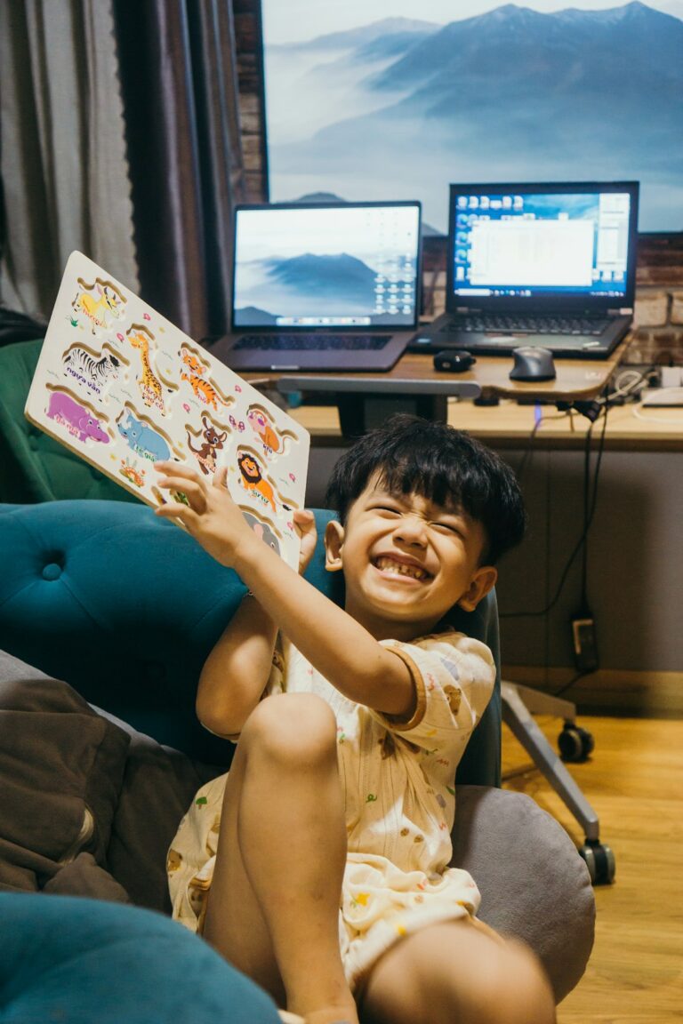 Child watching a Hebrew cartoon beside picture cards and a Hebrew children’s book.