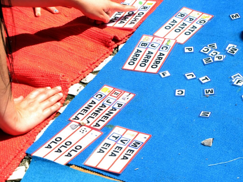 Children match Hebrew letter cards and colorful picture cards at a table during a playful language activity.