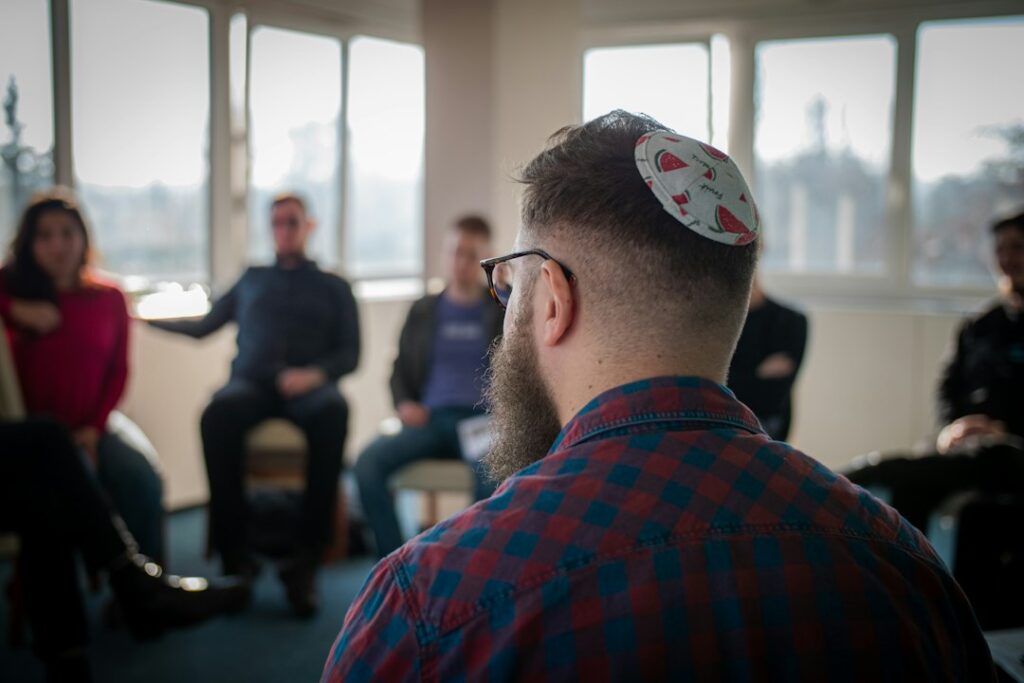 Two adults practice Hebrew at a table with notebooks, handwritten phrases, and cups of tea.