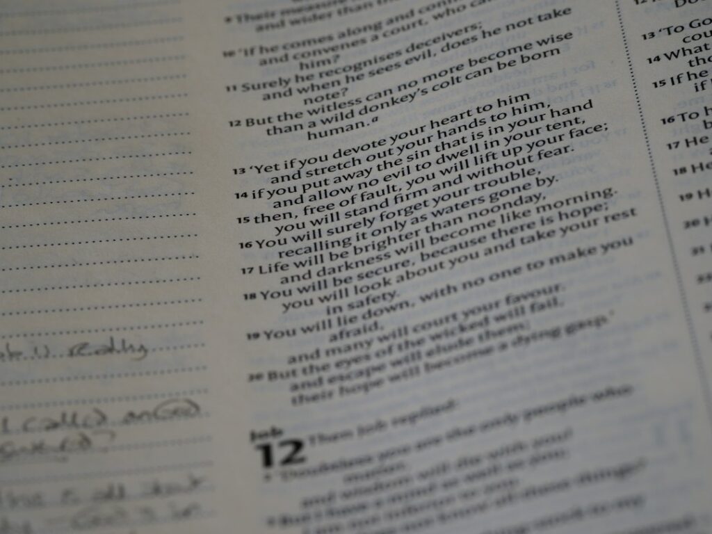 Adult and child practicing Hebrew words from a notebook at a kitchen table.