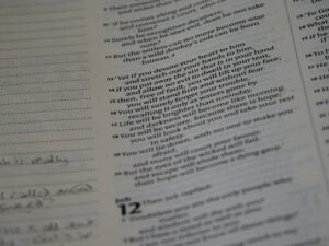 Adult and child practicing Hebrew words from a notebook at a kitchen table.