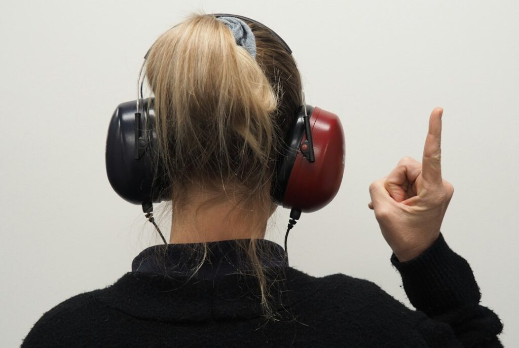 A learner listens to Hebrew audio while following a printed transcript at a home desk.