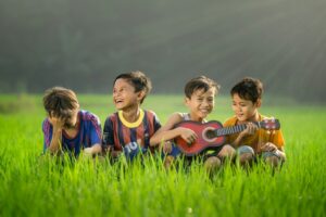 Children and an adult read Hebrew song sheets while singing together in a bright home learning space.