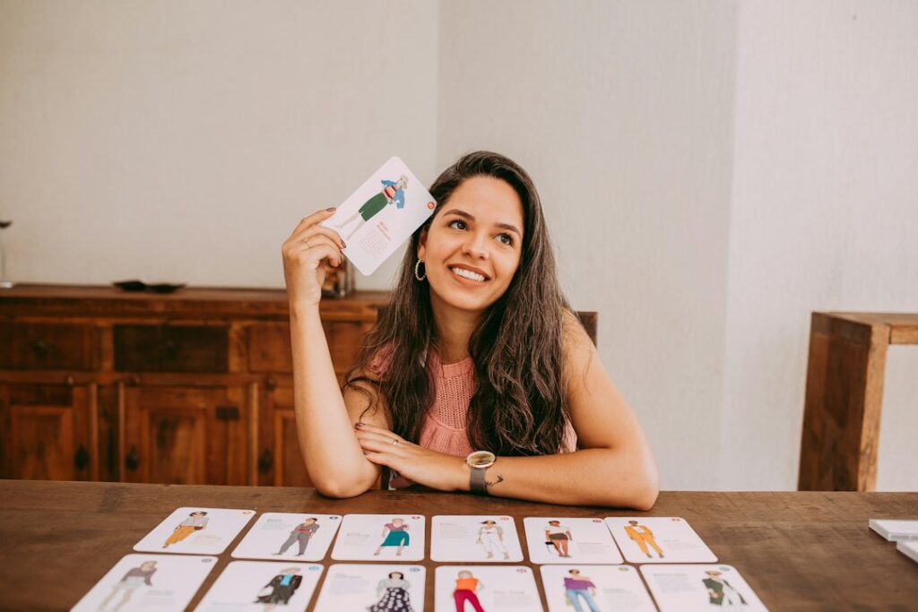 Person reviewing Hebrew flashcards with handwritten words, pronunciation notes, and a notebook at a kitchen table.
